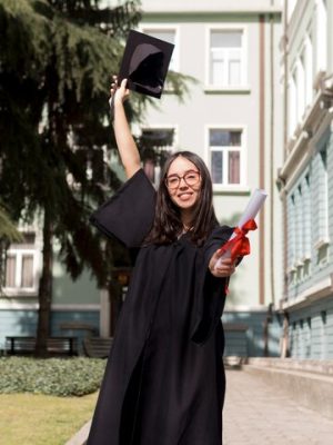 front-view-smiley-young-woman-wearing-graduation-gown_23-2148505261